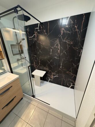 Transformation complète et pose de cabine de douche PMR avec paroi élégante effet marbre en remplacement d'une baignoire par Eau et Design rénovation salle de bain