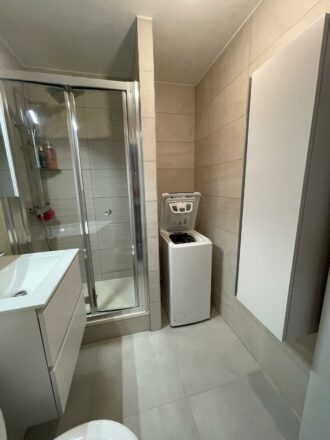 rénovation de petite salle de bain avec rangement et machine à laver par Eau & Design