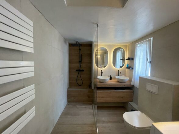 rénovation salle de bain par Eau & Design façon chalet chic vue de la douche italienne et la double vasque