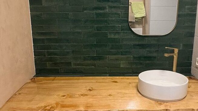 rénovation salle de bain Obernai avec Zellige vert émeraude, robinetterie dorée et plan de travail bois époxy